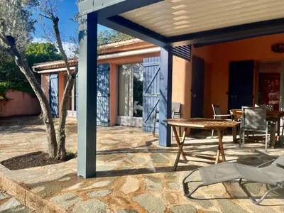 a patio with a wooden table at Villa Tarco in Porto-Vecchio