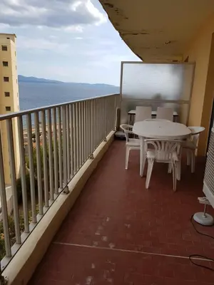 a balcony with a table and chairs and the ocean at Ajaccio VUE MER IMPRENABLE 4a5 Pers in Ajaccio