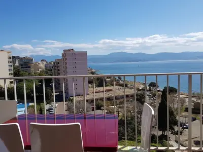 a balcony with a table and chairs and the ocean at Ajaccio VUE MER IMPRENABLE 4a5 Pers in Ajaccio