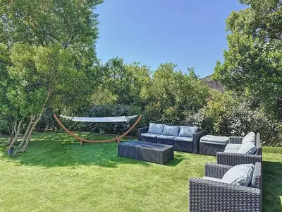 a yard with couches and a hammock in the grass at Bergerie A Mandria di Rondinara in Bonifacio