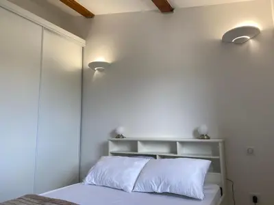 a bedroom with white walls and a bed with white pillows at Bergerie A Mandria di Rondinara in Bonifacio