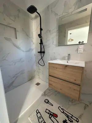 a bathroom with a sink and a shower and a mirror at Appartement dans résidence 3 étoiles in Lecci