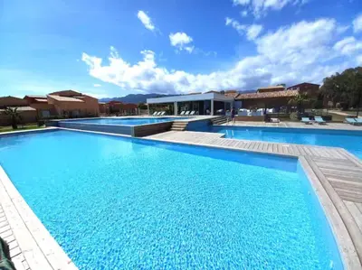 a large swimming pool with blue water at Appartement dans résidence 3 étoiles in Lecci