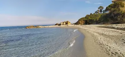 a sandy beach with a house and the ocean at Appt 4-6 couchages climatisé avec 2 piscines et 200 m des plages et criques in Linguizzetta