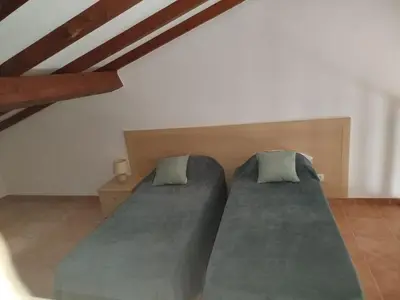 a bedroom with two beds in a attic at Appt 4-6 couchages climatisé avec 2 piscines et 200 m des plages et criques in Linguizzetta