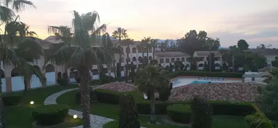 a view of the courtyard of a resort with palm trees at Appt 4-6 couchages climatisé avec 2 piscines et 200 m des plages et criques in Linguizzetta