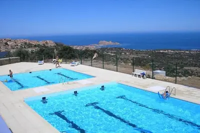 two swimming pools with the ocean in the background at Appartement à Speloncato dans la plaine du Reginu 2, pour 3 personnes in Speloncato