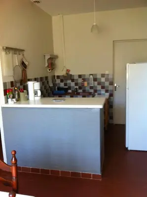 a kitchen with a white counter and a refrigerator at Appartement à Speloncato dans la plaine du Reginu 2, pour 3 personnes in Speloncato