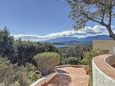 a garden with a pathway and a view of the water at Casa Blue Cala Rossa with Pool in Lecci