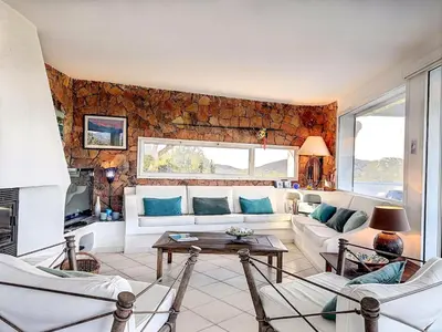 a living room with a white couch and a stone wall at Casa Blue Cala Rossa with Pool in Lecci