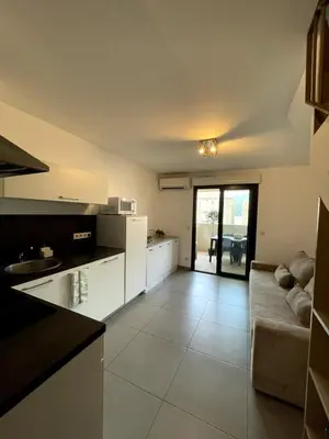 a large kitchen with a couch and a table at Apartment Propriano, Corsica in Propriano