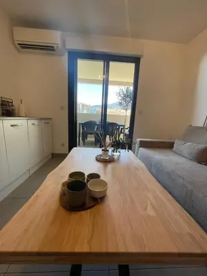 a living room with a wooden table with bowls on it at Apartment Propriano, Corsica in Propriano