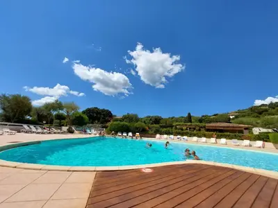 a large swimming pool with people in the water at Maison proche Porto Vecchio in Porto-Vecchio