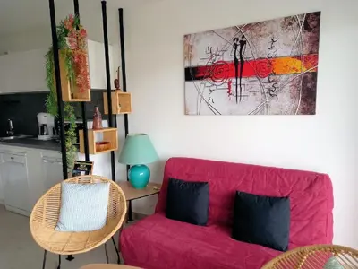 a living room with a pink couch and a kitchen at A casa in Propriano