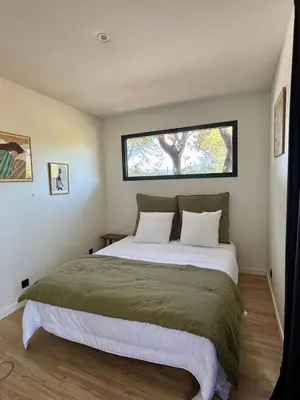 a bedroom with a large bed with a window at Lodge sous les oliviers in Propriano