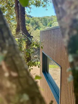 a house with a large window on the side of it at Lodge sous les oliviers in Propriano