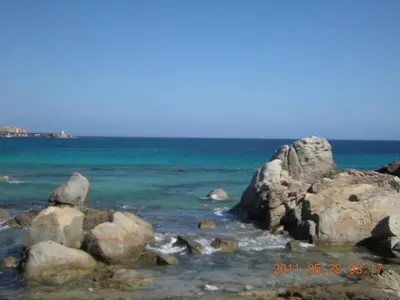 a group of rocks in the water on a beach at Appartement à Speloncato dans la plaine du Reginu 1, pour 3 personnes in Speloncato