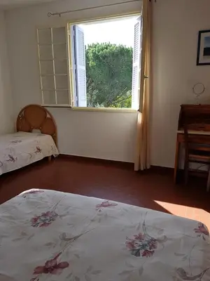 a bedroom with a bed and a large window at Appartement à Speloncato dans la plaine du Reginu 1, pour 3 personnes in Speloncato