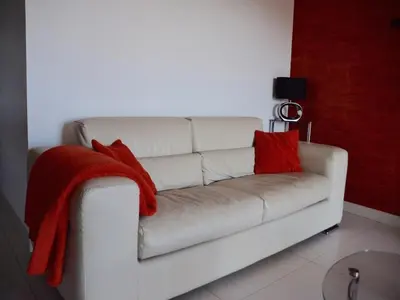 a white couch with two red pillows on it at NEPTUNE - Apartment 4 to 6 people - Port of Porto-Vecchio in Porto-Vecchio