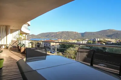 a balcony with a table and a view of the ocean at NEPTUNE - Apartment 4 to 6 people - Port of Porto-Vecchio in Porto-Vecchio