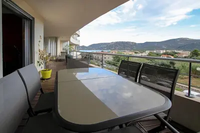 a table and chairs on a balcony with a view at NEPTUNE - Apartment 4 to 6 people - Port of Porto-Vecchio in Porto-Vecchio