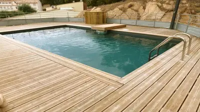 a large swimming pool with a wooden deck at NEPTUNE - Apartment 4 to 6 people - Port of Porto-Vecchio in Porto-Vecchio