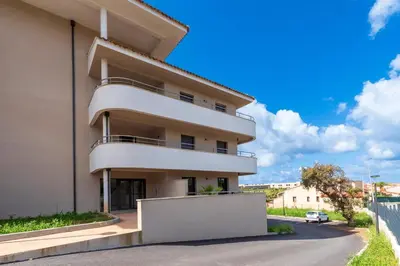 a building with balconies on the side of it at Les Vagues d'Agosta in Albitreccia