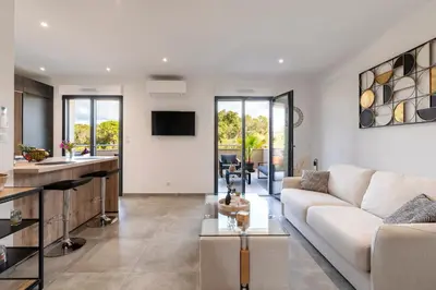a living room with a couch and a kitchen at Les Vagues d'Agosta in Albitreccia