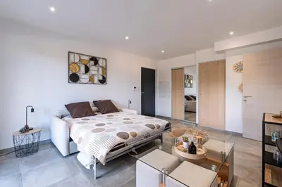 a bedroom with a bed and a living room at Les Vagues d'Agosta in Albitreccia