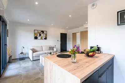 a kitchen with a large island in a living room at Les Vagues d'Agosta in Albitreccia
