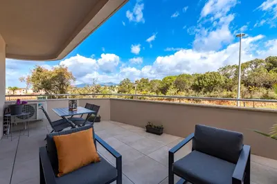 a balcony with chairs and a table with a view at Les Vagues d'Agosta in Albitreccia