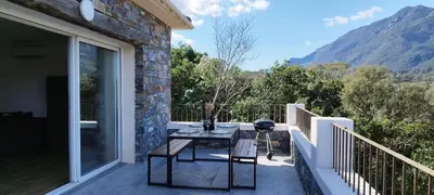a patio with a table and chairs on a balcony at Villa Viktoriia in San-Nicolao