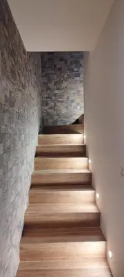 a staircase with wood floors and a brick wall at Villa Viktoriia in San-Nicolao