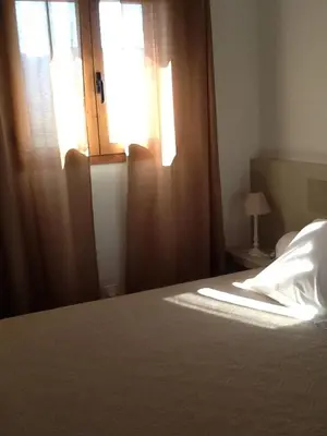 a bedroom with a bed with a window and a bedspread at jolie location in Porto-Vecchio