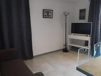 a living room with a flat screen tv and a couch at jolie location in Porto-Vecchio