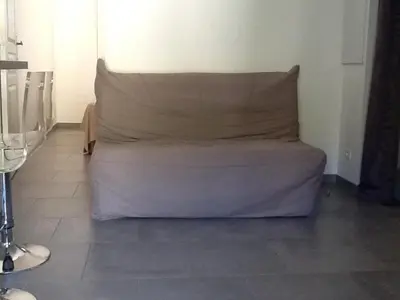 a bed sitting in the corner of a room at jolie location in Porto-Vecchio