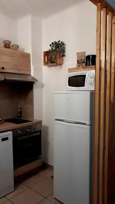 a kitchen with a white refrigerator and a microwave at Terra Corsa Duplex T2 in Porto Ota