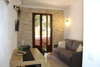 a living room with a couch and a table at Terra Corsa Duplex T2 in Porto Ota