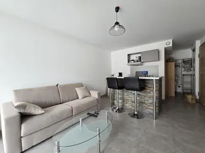 a living room with a couch and a glass table at Charmant studio avec extérieur in Corte