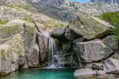 a waterfall on the side of a rocky mountain at Charmant studio avec extérieur in Corte
