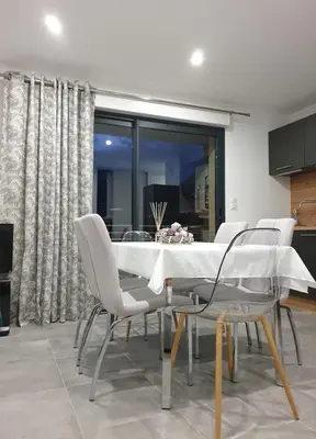 a dining room with a white table and chairs at T3 Corté vue sur la Citadelle in Corte