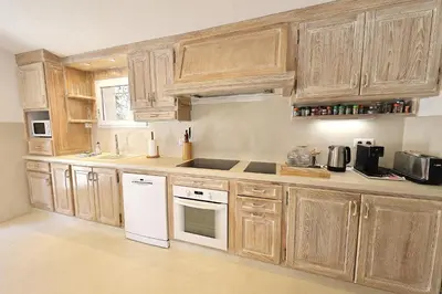 a kitchen with wooden cabinets and white appliances at Villa Luma, 3 Chambres avec Piscine Chauffée in Figari