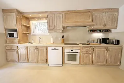 a kitchen with wooden cabinets and white appliances at Villa Luma, 3 Chambres avec Piscine Chauffée in Figari