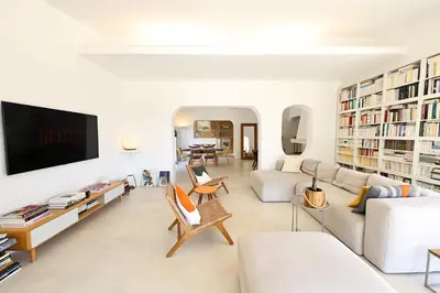 a living room with white furniture and bookshelves at Villa Luma, 3 Chambres avec Piscine Chauffée in Figari