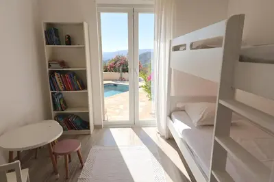 a bedroom with a bed and a table and a window at Villa Luma, 3 Chambres avec Piscine Chauffée in Figari
