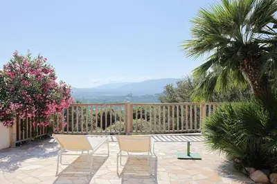 a patio with two chairs and a wooden fence at Villa Luma, 3 Chambres avec Piscine Chauffée in Figari
