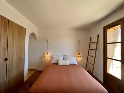 a bedroom with a large bed with two pillows at Bergerie de charme, piscine chauffée, vue nature entre mer et montagne, Sotta in Sotta