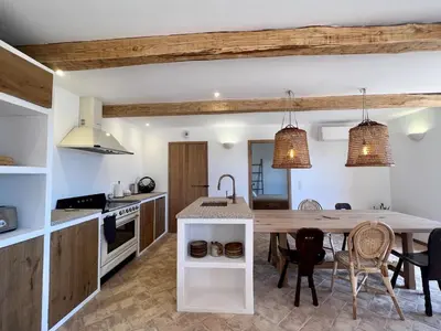 a kitchen with a large wooden table and chairs at Bergerie de charme, piscine chauffée, vue nature entre mer et montagne, Sotta in Sotta