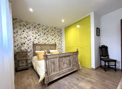 a bedroom with a bed and a yellow door at FURIANI Appartement avec Piscine dans Villa in Furiani