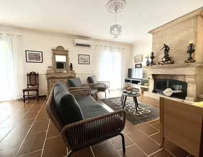 a living room with a couch and a fireplace at FURIANI Appartement avec Piscine dans Villa in Furiani
